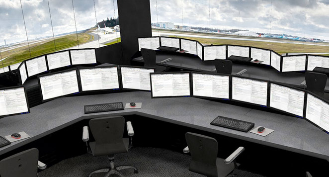 airport control room with consoles, monitors, and view of runway
