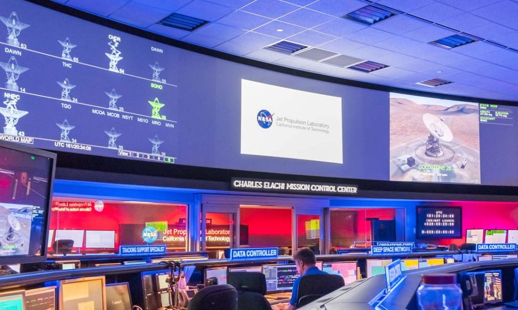 photo of inside of mission control facility with operators sitting at control room furniture
